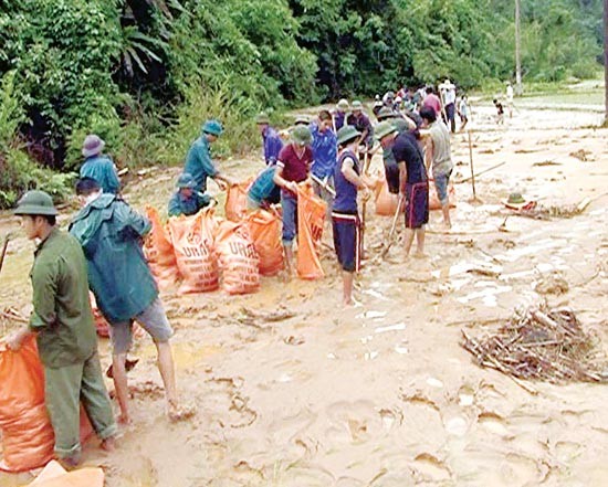 Residents repair a damaged road in Bac Kan province (Photo: SGGP)
